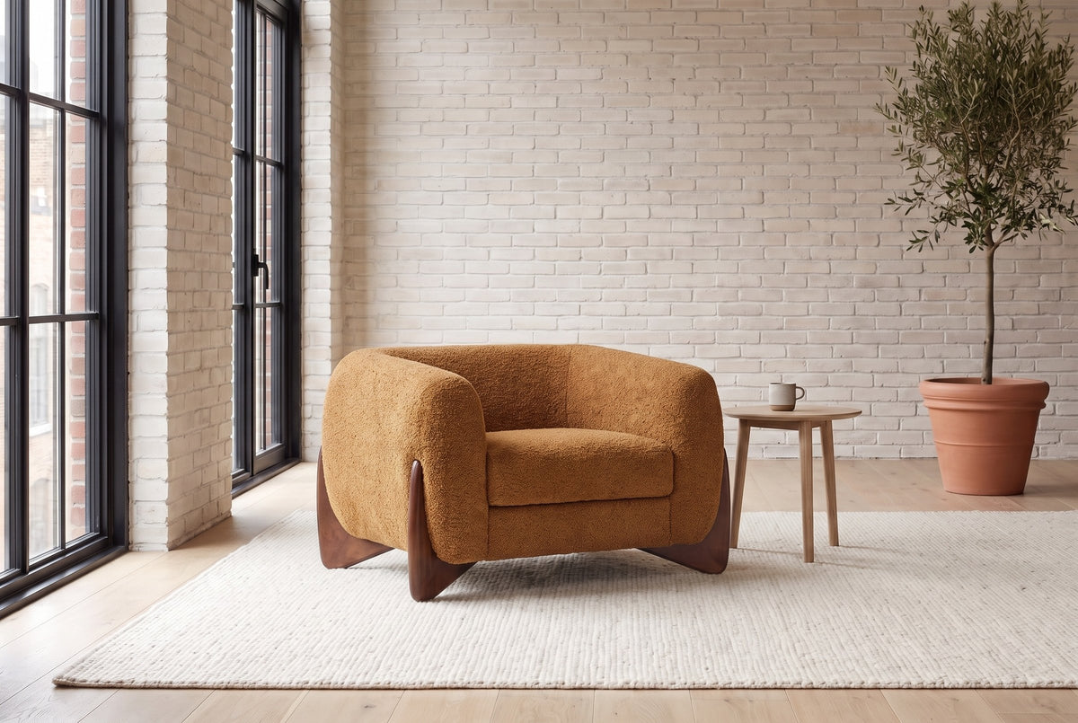 Cervia lounge chair in a bright Montreal loft with whitewashed brick, an ivory rug and an olive tree (Caramel)