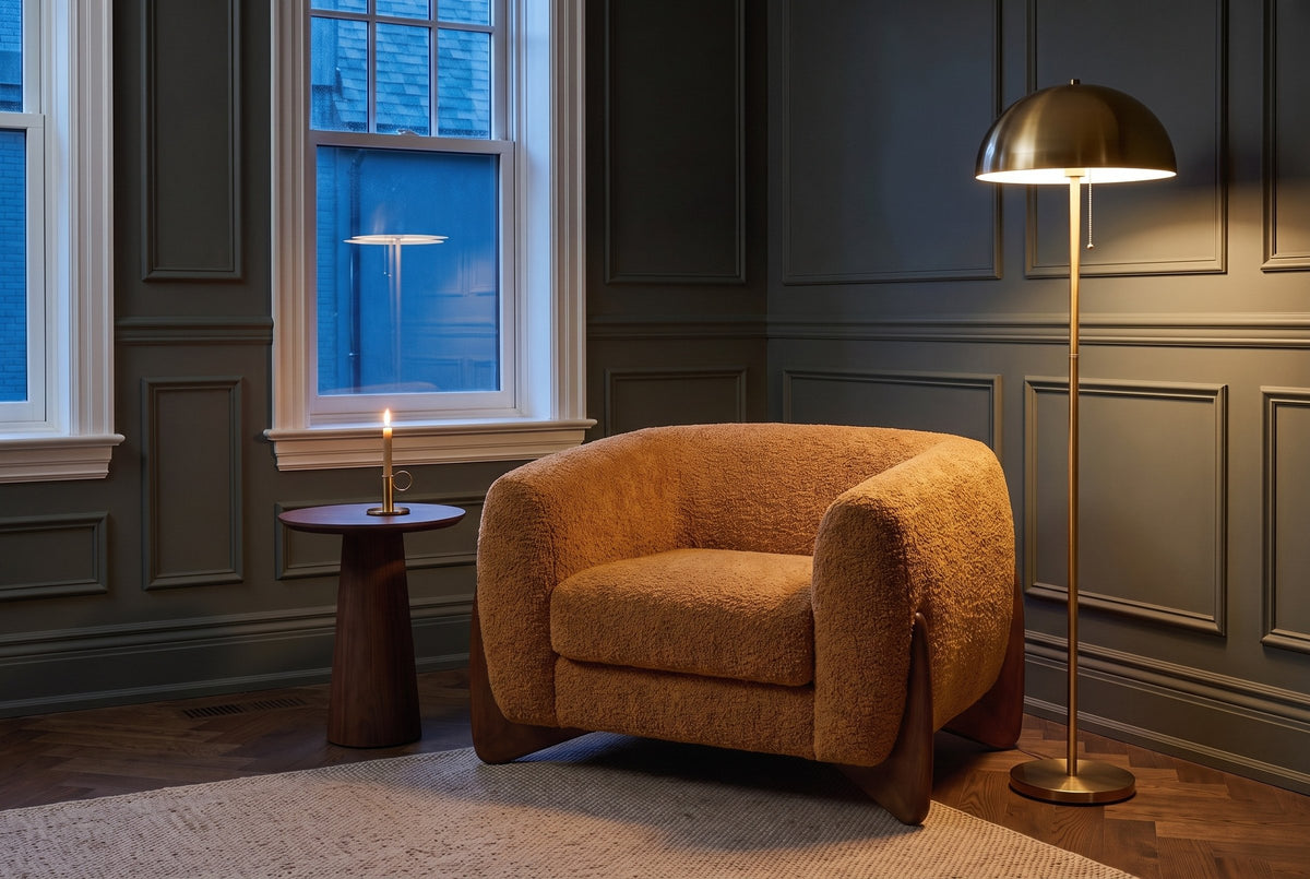 Cervia lounge chair in a panelled Toronto den at dusk beside a brass floor lamp and a walnut side table (Caramel)