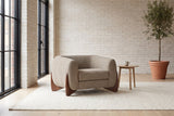 Cervia lounge chair in a bright Montreal loft with whitewashed brick, an ivory rug and an olive tree