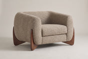 Cervia boucle lounge chair in Light Brown, three-quarter view on a warm grey studio backdrop