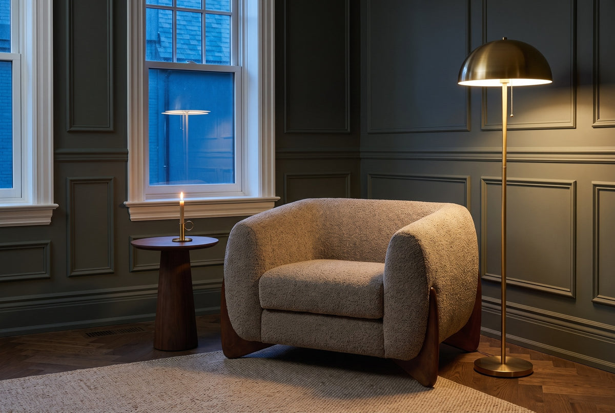 Cervia lounge chair in a panelled Toronto den at dusk beside a brass floor lamp and a walnut side table