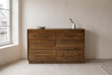 Cervinia reclaimed pine dresser against an off-white plaster wall in an old stone house bedroom in Quebec City, a stoneware bowl on top