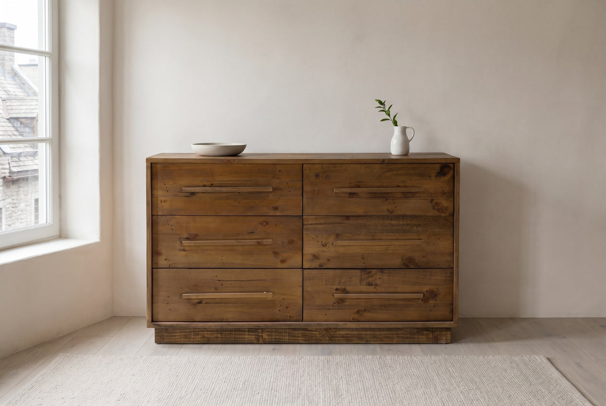 Cervinia reclaimed pine dresser against an off-white plaster wall in an old stone house bedroom in Quebec City, a stoneware bowl on top