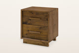 Cervinia reclaimed pine nightstand in weathered brown: two plank drawers with wooden bar pulls in a plain frame, on a recessed plinth, three-quarter view on a warm white studio backdrop