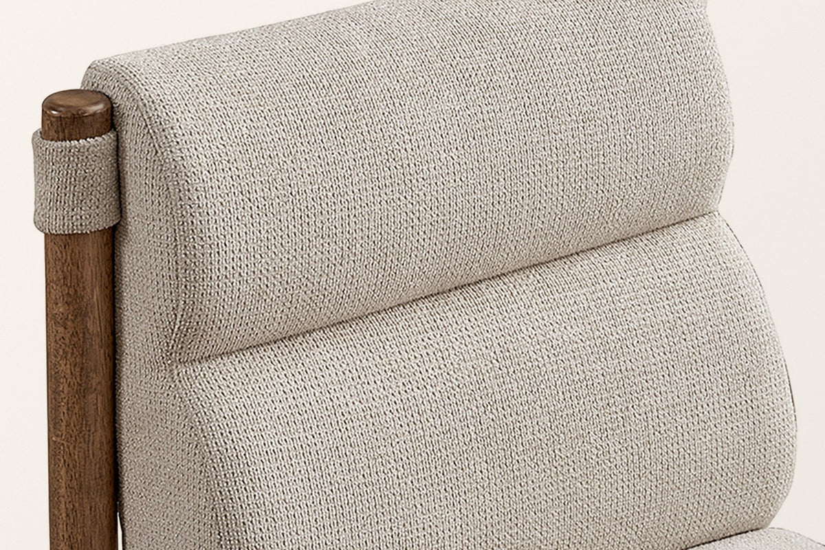 Close-up of the Cervo back: the rounded top roll, the woven fabric and a fabric loop around the top of a round walnut post