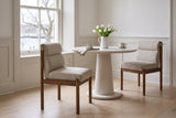 Two Cervo dining chairs in beige and walnut at a round white-oiled oak pedestal table in a Halifax dining room with white pan