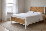 Cesana sunburst bed made up with white linen in a calm South End, Halifax bedroom, the harbour through a tall sash window