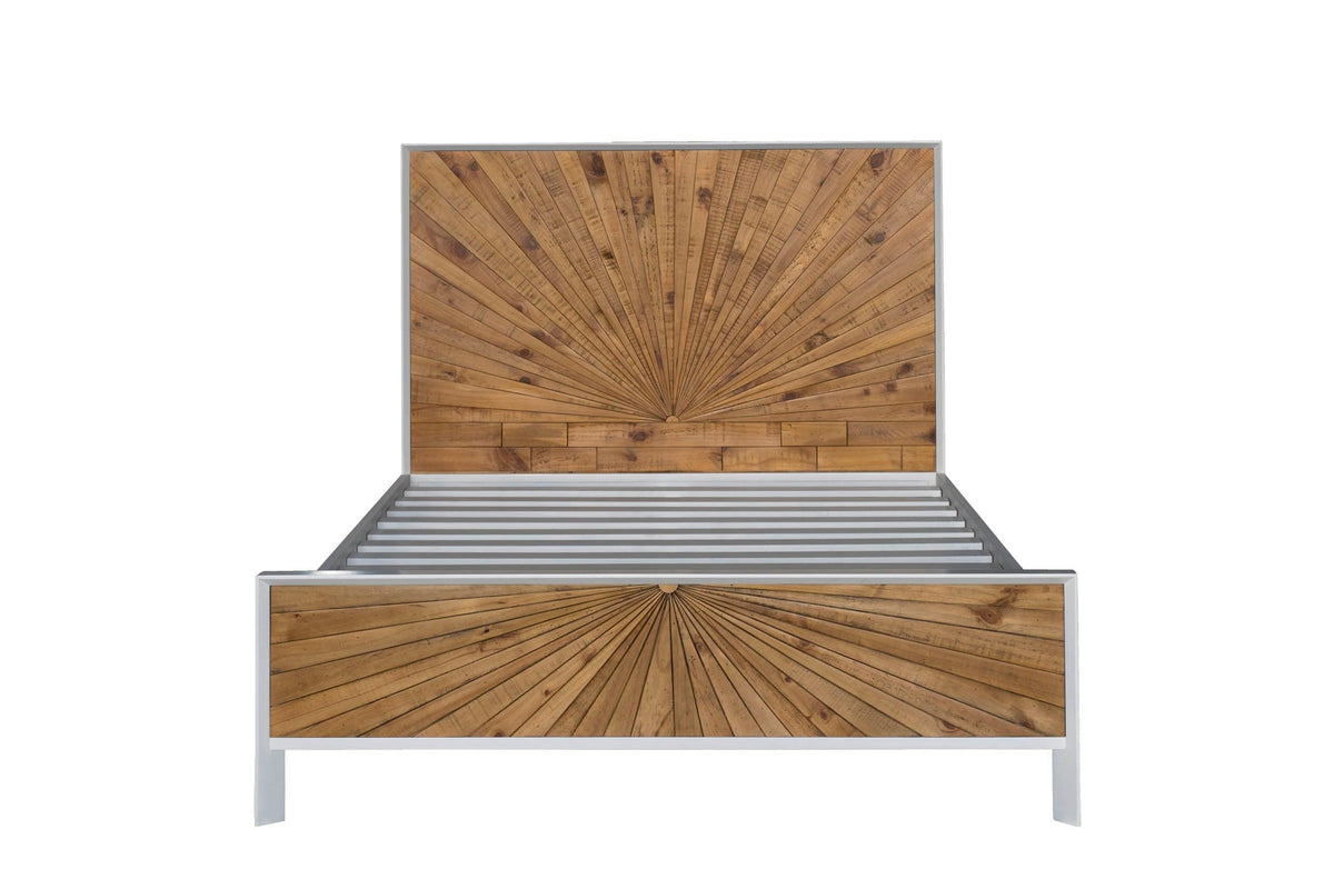 Cesana bed seen from the foot end: the pine sunburst headboard above the slats and the low sunburst footboard in a white frame