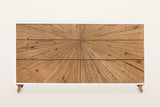 Cesana dresser from the front: six drawers in two columns of three, one brass pull centred on each, the pine strips radiating from one point near the middle