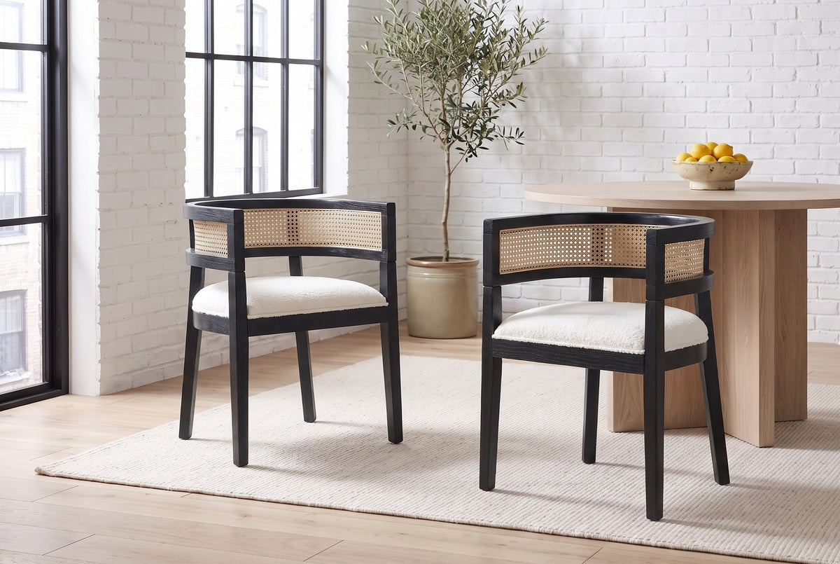 Two Cesena dining chairs in Black pulled out from a pale-oak pedestal table in a white-brick Montreal loft