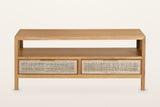 Cetara coffee table in Natural, front view on a warm white studio backdrop: the open shelf over two wicker drawers