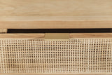 Close-up of the Cetara drawer front: the ash top edge, the slim antique brass pull and the open square weave of the wicker