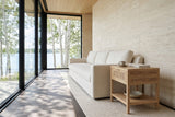 Cetara side table in Natural ash and wicker at the end of a warm-white linen sofa in a Sylvan Lake house