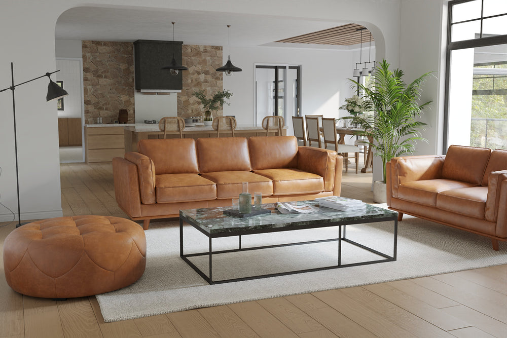 In a Living Room, There is Sitting A Luxurious, Royal Cognac, Kiln Dried Wood Frame, Artisan Round Full Leather Ottoman with a Set of Three Sofa and a Loveseat Sofa.
