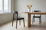 Two Chiavenna dining chairs in mocha at a light-oak table in a Calgary dining room