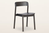 Chiavenna curved-back dining chair in mocha, three-quarter view on a warm white studio backdrop