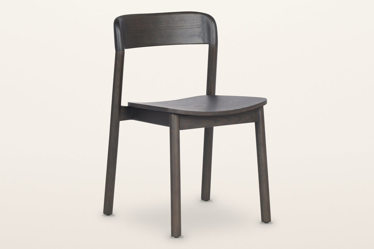 Chiavenna curved-back dining chair in mocha, three-quarter view on a warm white studio backdrop