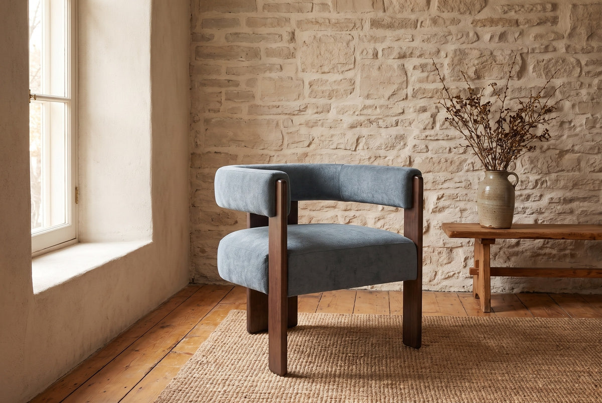 Chioggia accent chair against a limestone wall on pine floorboards and a jute rug