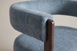 Close-up of the blue velvet back band ending on the rounded top of a walnut front leg