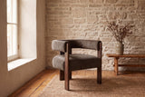 Chioggia accent chair against a limestone wall on pine floorboards and a jute rug (Dark Brown)