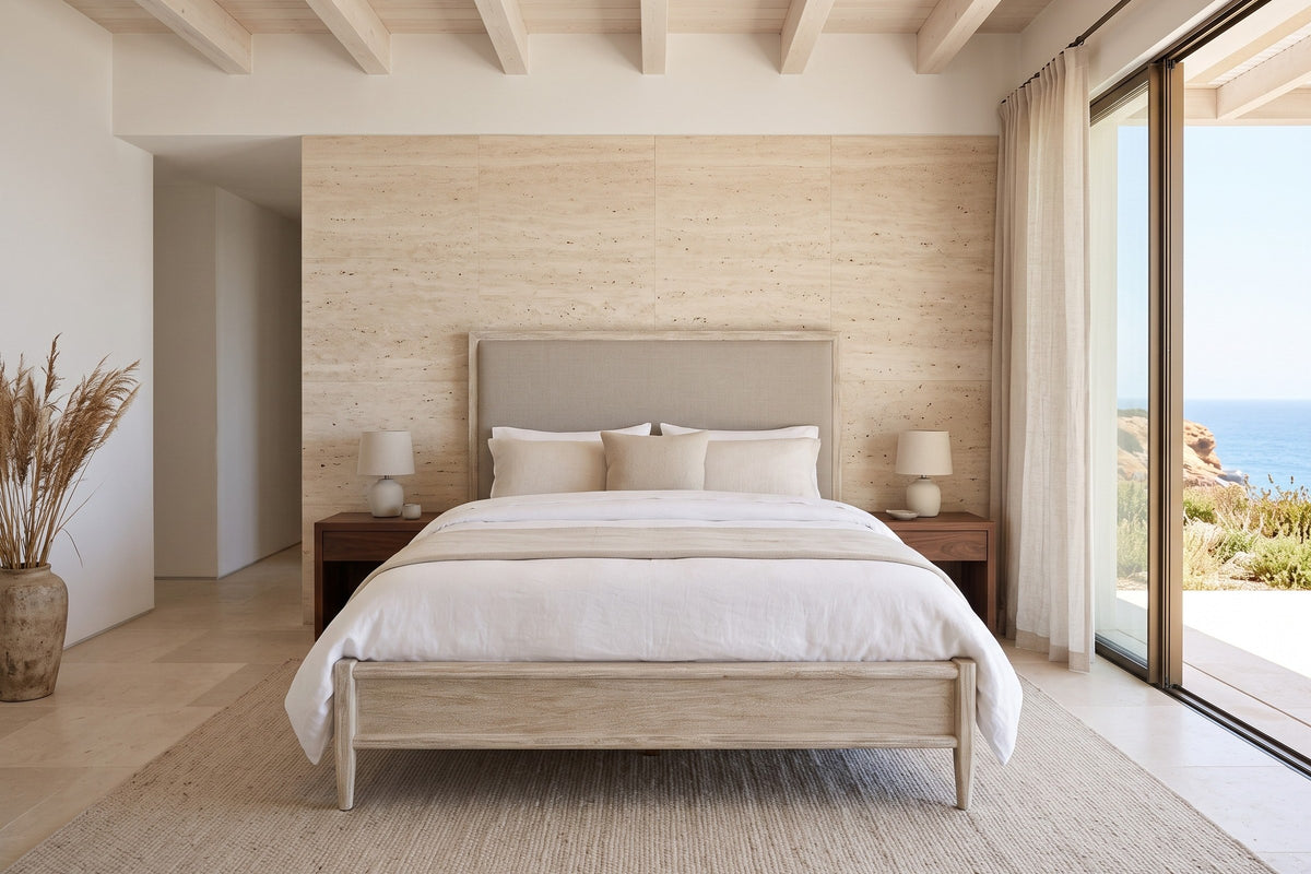 Front view of the Chiusdino bed in a bedroom in an Aljezur cliff house in Portugal, with a travertine wall