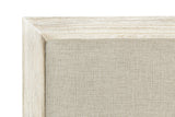 Close-up of the Chiusdino headboard: the greige woven linen-look panel inside the whitewashed frame with a mitred corner