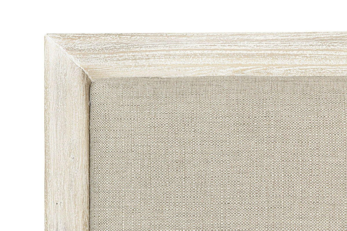 Close-up of the Chiusdino headboard: the greige woven linen-look panel inside the whitewashed frame with a mitred corner