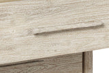 Close-up of a Chiusdino drawer front: the slim bar pull and the pale whitewash over the grain