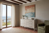 Chiusdino dresser in a pale whitewashed finish against a greige plaster wall in a Collioure house, with chestnut beams