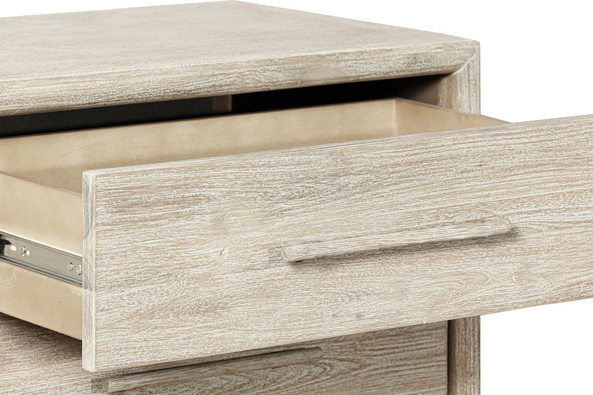 Close-up of a Chiusdino drawer pulled out under the rounded top edge, with its slim bar pull and the whitewashed grain