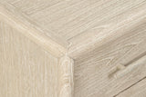 Close-up of a Chiusdino top corner: the rounded frame meeting the corner post, the whitewashed grain and a drawer pull