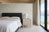 Chiusdino nightstand in whitewashed wood beside a charcoal channel-tufted bed in a Kluane Lake bedroom, Yukon