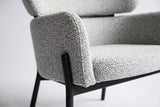 Close-up of the Light Gray boucle on the Chiusi arm and seat pad, with a slim steel leg and the floating back pad