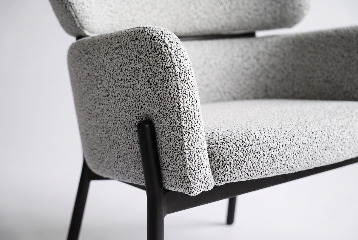 Close-up of the Light Gray boucle on the Chiusi arm and seat pad, with a slim steel leg and the floating back pad