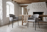 Two Chiusi dining chairs in a whitewashed stone dining room in Quebec City