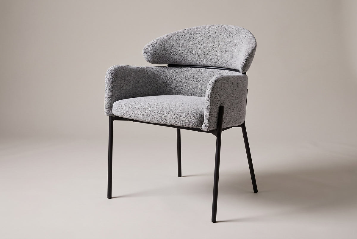 Chiusi boucle dining chair in Light Gray, three-quarter view on a warm grey studio backdrop
