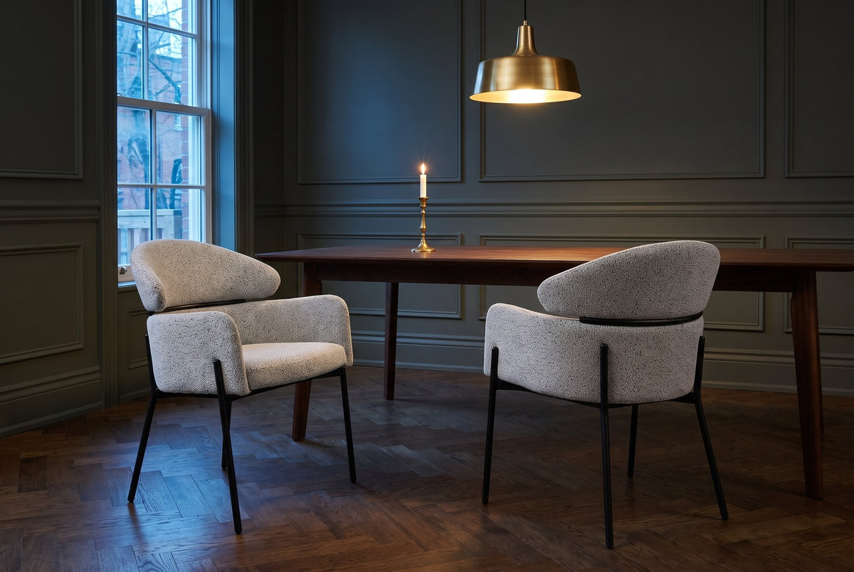 Two Chiusi dining chairs at a walnut table in a dark green panelled Toronto dining room at dusk