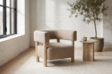 Cingoli boucle chair in a Montreal loft living room with a white brick wall, a steel window and a travertine side table