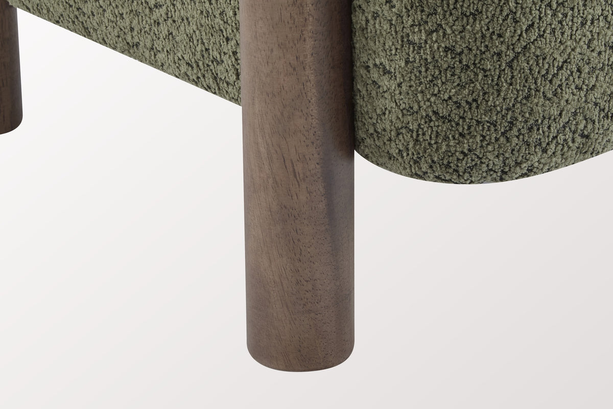 Close-up of a round walnut-stained rubberwood leg beside the rounded Olive Green boucle seat of the Cingoli chair