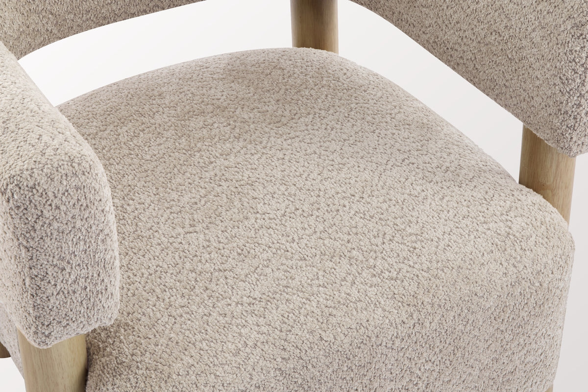 Close-up of the Wheat boucle seat and the squared-off arm of the Cingoli chair