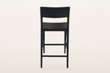 Cison counter stool in Black from behind on a warm white studio backdrop