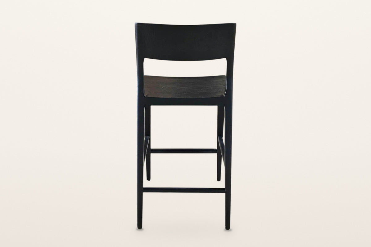 Cison counter stool in Black from behind on a warm white studio backdrop