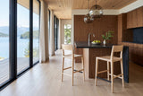Two Cison counter stools in Natural at a charcoal soapstone island in a Lasqueti Island house, with walnut cabinetry