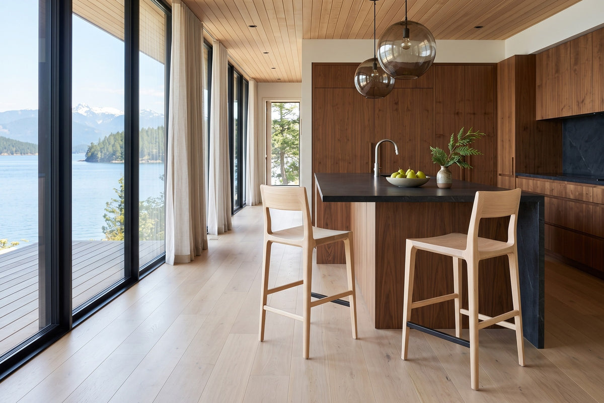 Two Cison counter stools in Natural at a charcoal soapstone island in a Lasqueti Island house, with walnut cabinetry