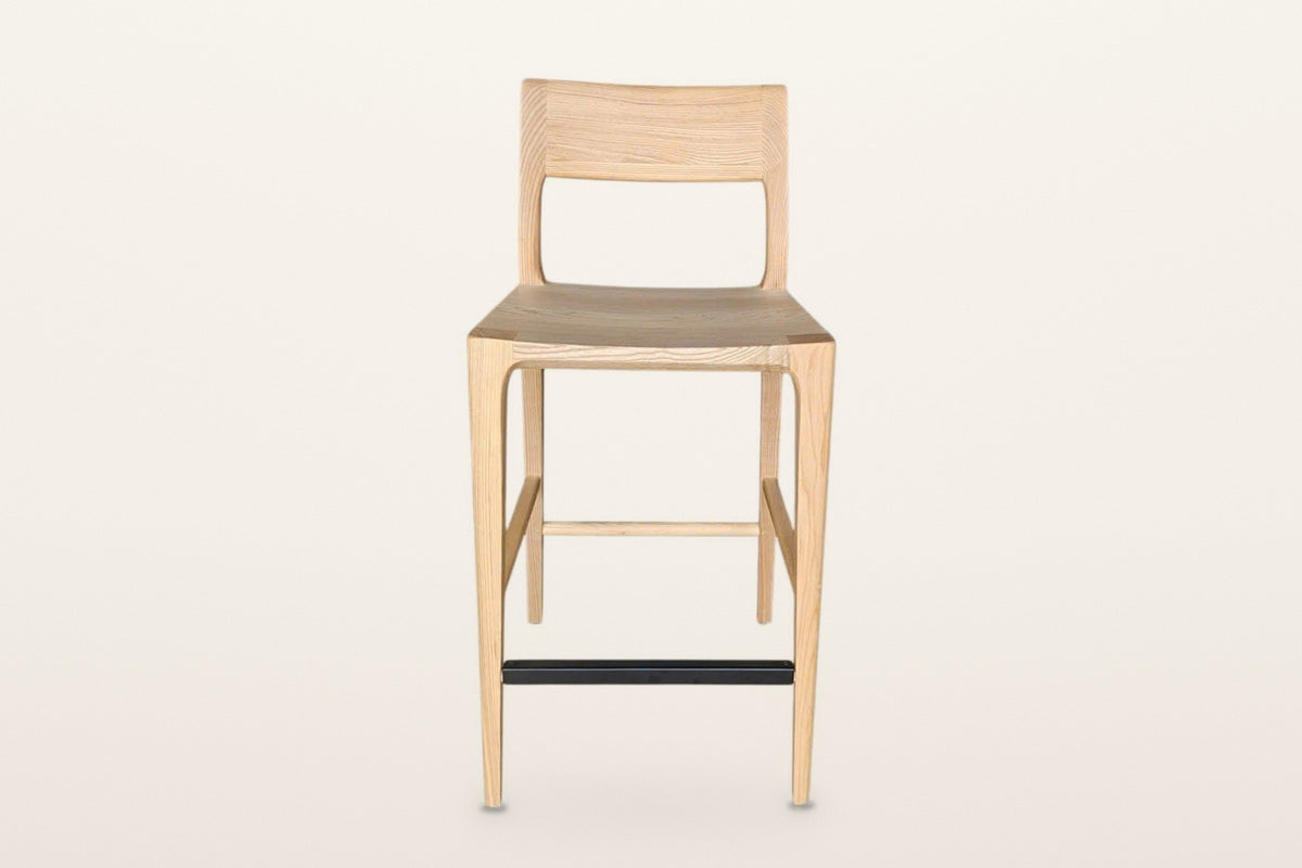 Cison counter stool in Natural, straight front view on a warm white studio backdrop: the curved backrest