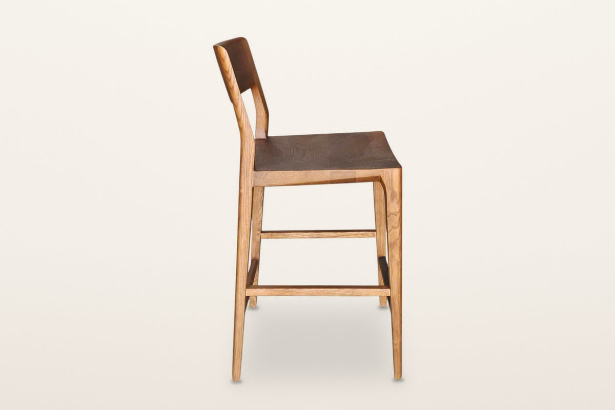 Cison counter stool in Warm Brown, side view on a warm white studio backdrop