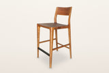 Cison solid ash counter stool in Warm Brown, three-quarter view on a warm white studio backdrop: warm brown ash with a black