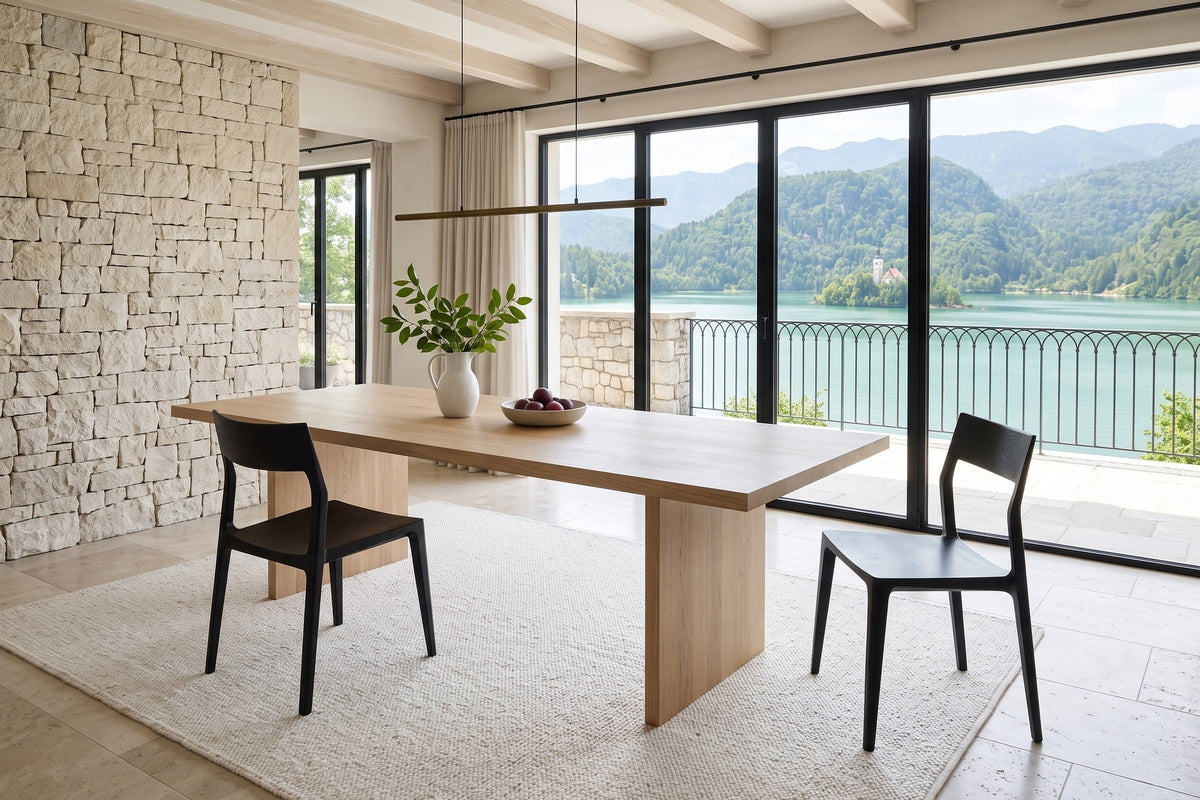 Two Cison dining chairs in Black at a light-oak table in a Lake Bled villa