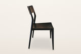 Cison dining chair in Black, side view on a warm white studio backdrop: the back post leans back and runs down into the rear