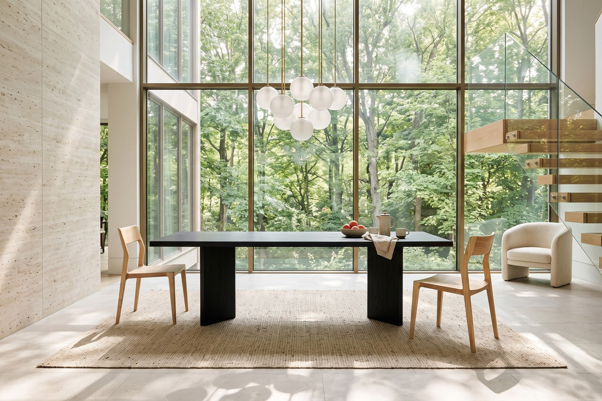 Cison dining chairs in Natural at the two ends of a black oak table in a Rouge Valley ravine house